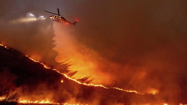 Water is dropped by helicopter on the Kenneth Fire in the West Hills section of Los Angeles, Thursday, Jan. 9, 2025. (AP Photo/Ethan Swope)