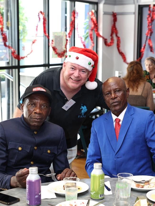 The Cairns Community Christmas Lunch was served up on Christmas Day at St Augustine's College, totally free of charge, thanks to the generosity of Cairns businesses, personal donations and a small army of volunteers. Eddie Jamba and Augustine Massumbuko from the Congo enjoy the charity lunch, organised by Cairns Community Christmas Lunch president David Lennie (centre). Picture: Brendan Radke