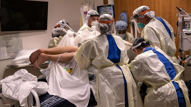 A “prone team’’, wearing personal protective equipment, turns a COVID-19 patient onto his stomach in a Stamford Hospital intensive care unit.