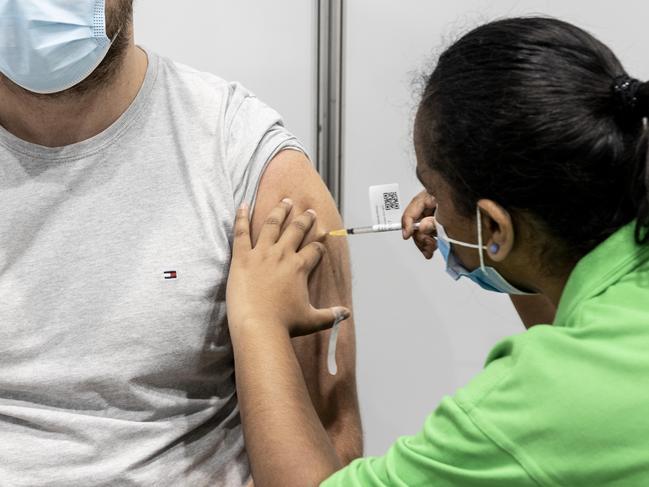 BRISBANE AUSTRALIA - NewsWire Photos NOVEMBER 1, 2021: Rhys Barnes gets a Pfizer vaccination from enrolled nurse Maria Mathews at the Brisbane Convention and Exhibition centre vaccination hub. NewsWire / Sarah Marshall