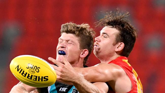 Mitch Georgiades (left) of the Power in action during the Round 1 AFL match between the Gold Coast Suns and Port Adelaide Power at Metricon Stadium on the Gold Coast, Saturday, March 21, 2020. (AAP Image/Darren England) NO ARCHIVING, EDITORIAL USE ONLY