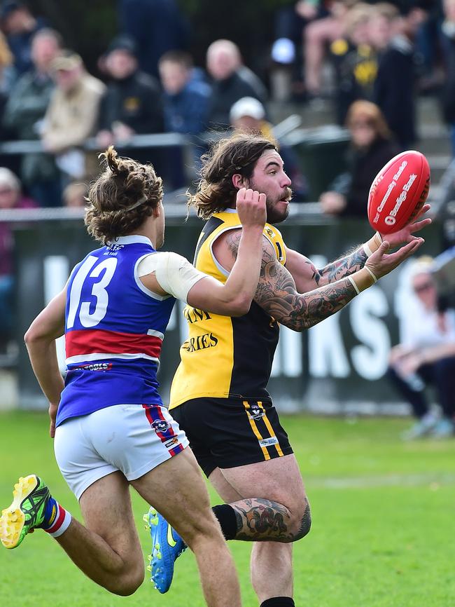 Frankston YCW’s Kyle Hutchinson pursued by Mornington’s Ryan Odell. Picture: Derrick den Hollander