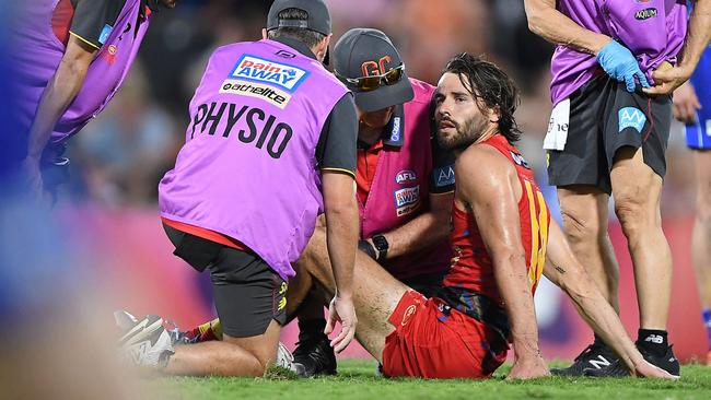 Lachie Weller is tended to by medicos during the Suns’ clash with North Melbourne. Picture: AFL Photos/Getty Images