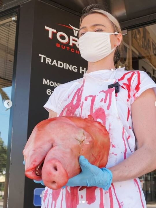 The young Western Australian woman posted her latest stunt to social media where she is seen holding a pig’s head. Picture: Supplied/Instagram