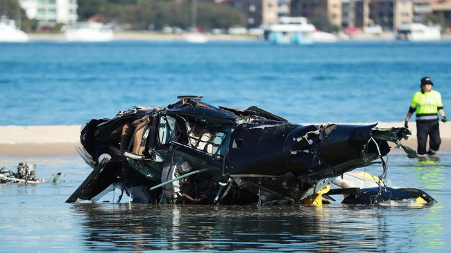 Police and ATSB Officers recover the wreckage after four people were killed in the helicopter crash near Sea World. Picture: Scott Powick.