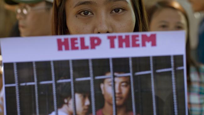 A protester displays a picture featuring Myanmar migrants Win Zaw Htun, right, and Zaw Lin during a demonstration against the Thai court's verdict sentencing them to death. Picture: Gemunu Amarasinghe