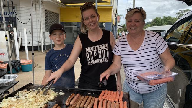 Southeast Queensland residents Zen Hammant, 11, Cassie Duel and Karen Rush cook a free barbecue at the intersection of Terania and Bridge Streets for flood-affected North Lismore residents on Saturday. Picture: Stuart Cumming