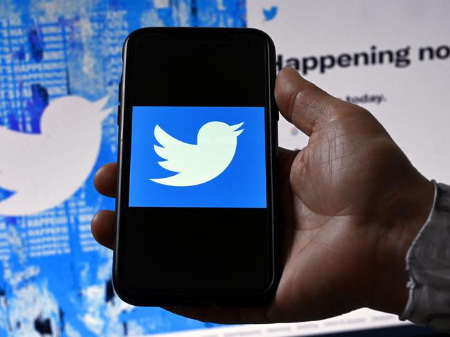 (FILES) In this file photo illustration taken on April 26, 2022, a phone screen displays the Twitter logo on a Twitter page background in Washington, DC. - Twitter said on September 1, 2022, it has begun actively testing an edit button, after months of publicly discussing such a tweak. The trial of 