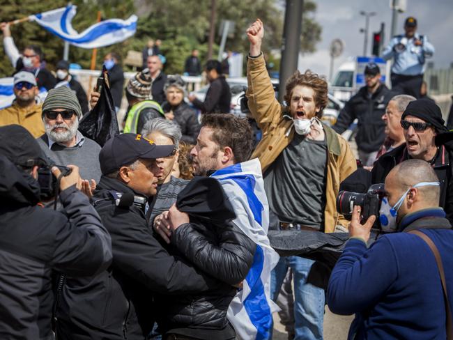 Israeli police officers scuffle with a man during a protest outside the Israeli parliament in Jerusalem on Thursday. Hundreds of people defied restrictions on large gatherings and others were blocked by police from reaching the area as they accused Prime Minister Benjamin Netanyahu's government of exploiting the coronavirus crisis. Picture: AP Photo/Eyal Warshavsky