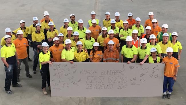 Knauf Bundaberg team holding up the first plasterboard made at the factory in 2017. Photo Contributed