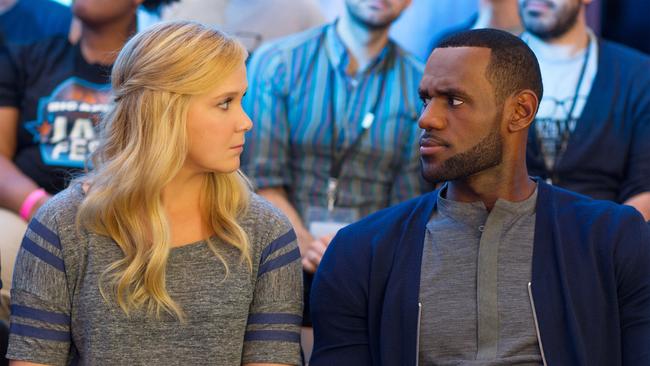 This image released by Universal Pictures shows Amy Schumer, left, and LeBron James, in a scene from the comedy, Trainwreck. (Mary Cybulski/Universal Pictures via AP)