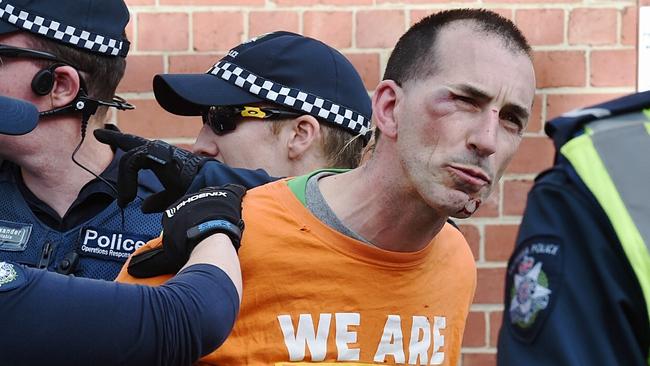 A left wing protester is restrained by police in Melbourne. Picture: Jake Nowakowski