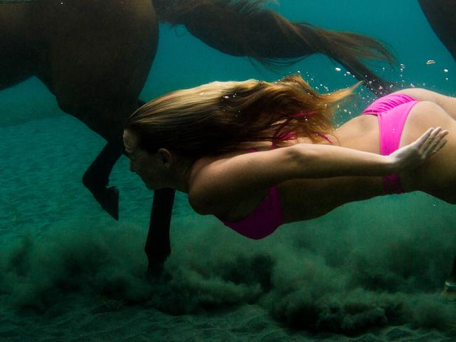 PIC BY SARAH LEE / CATERS NEWS - (PICTURED: Alison Teal swimming with horses underwater in Dominica.) A female adventurer who travels the world tackling dangerous jungles and uncharted wilderness is a real life Indiana JANE. Alison Teal, 30, has been on wild adventures across the globe in more than 40 countries including Syria, Tibet and the Maldives. The blonde beauty has even kissed a cobra - which she credits for saving her life when thanks to an ancient Moroccan tradition. She grew up with her adventure photographer parents David Blehert and Deborah Koehn who would take her with them on their constant travels. SEE CATERS COPY