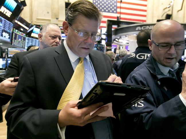 Trader Edward Shreier, center, and specialist Mario Picone, right, work on the floor of the New York Stock Exchange, Friday, May 6, 2016. Stocks were slightly lower in early trading Friday after a report on the U.S. economy showed a significant slowdown in hiring last month, echoing weakness seen earlier in the week in Europe and Asia. (AP Photo/Richard Drew)
