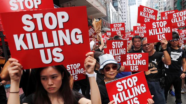 Protesters hold placards as they attend the demonstration. Picture: Reuters