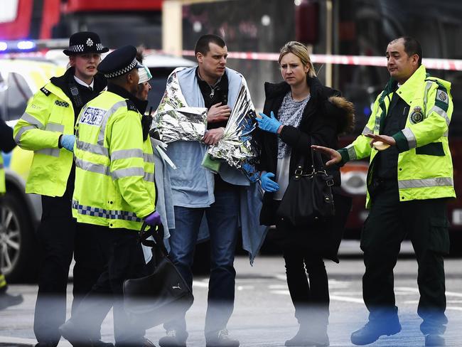 An injured member of the public being helped by emergency services. A list of the attacker’s family and associates is being pursued.