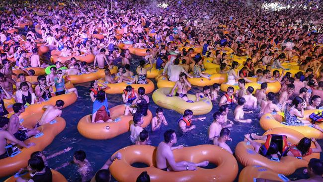 Thousands of people are pictured at a pool party in Wuhan, ignoring social distancing rules, as Chinese media defend attacks on the event as ‘sour grapes’. Picture: AFP