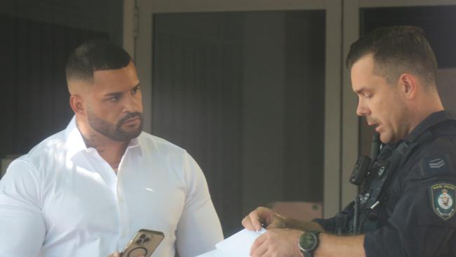 Blake Waterhouse (left), of Warners Bay, talks to a police officer outside Wyong Local Court where he pleaded guilty to doing a burnout in The Entrance Hotel car park. Picture: NewsLocal