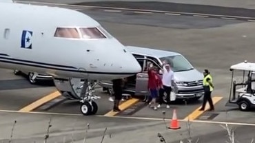Elton John and his husband David Furnish wave to fans before departing Hamilton Island on a private jet on Sunday. Picture: Supplied