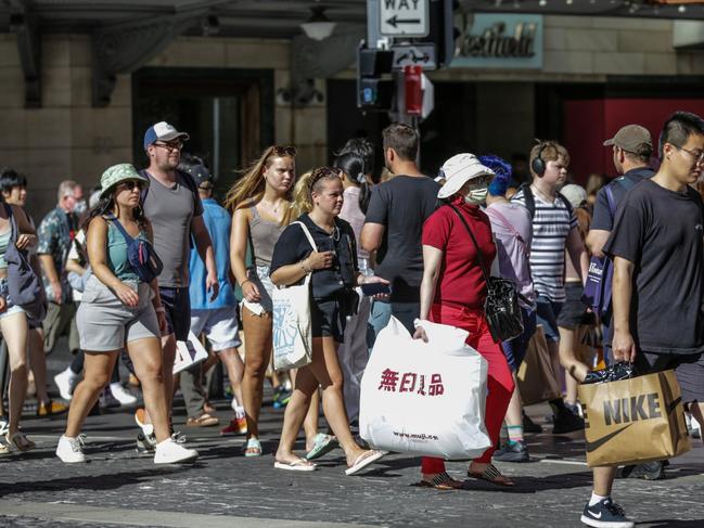 SYDNEY, AUSTRALIA - DECEMBER 26: People walk along George Street on Boxing Day on December 26, 2022 in Sydney, Australia. Retailers offer massive discounts and enticing deals on the boxing day public holiday in Australia, attracting many shoppers who are keen to take advantage of bargains once Christmas is over. (Photo by Roni Bintang/Getty Images)