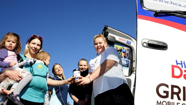 Karla Peterson with Isabella and Jacob gets a cup of coffee from student volunteers from Kellyville High School. Picture: Peter Kelly