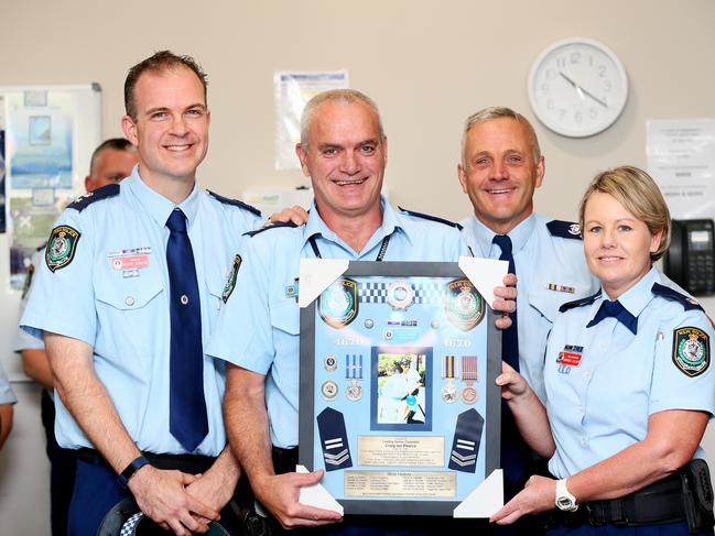 Traffic and Highway Patrol officer Craig Pearce was presented a framed keepsake. (AAP Image/Sue Graham)