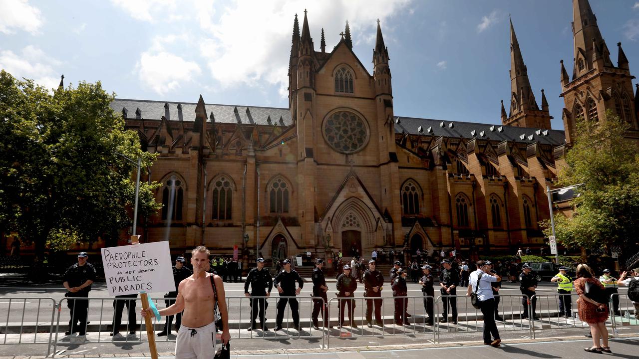 A protester holds a sign that reads ‘Paedophile protector's don’t deserve public parades’. Picture: NCA NewsWire / Damian Shaw