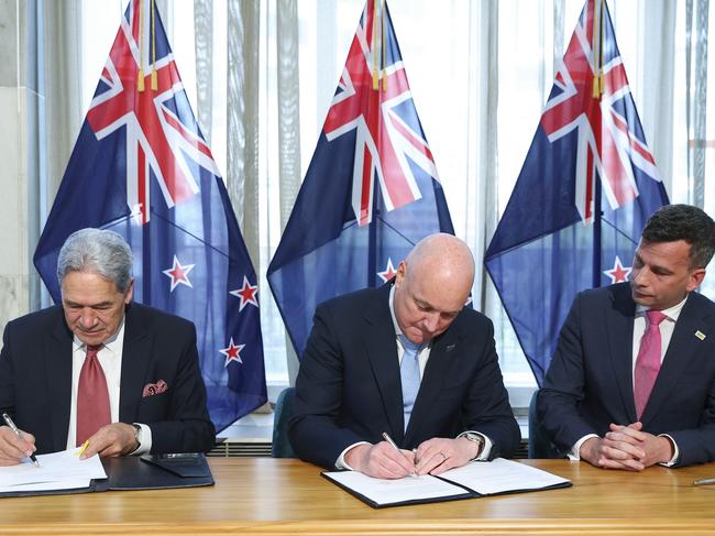 WELLINGTON, NEW ZEALAND - NOVEMBER 24: New Zealand First leader Winston Peters, incoming Prime Minister Christopher Luxon and ACT leader David Seymour sign the coalition agreement during a signing ceremony at Parliament on November 24, 2023 in Wellington, New Zealand. The National Party won the most votes in New Zealand's general elections held last month, but needs the support of both the ACT Party and New Zealand First to form a governing majority. (Photo by Hagen Hopkins/Getty Images)