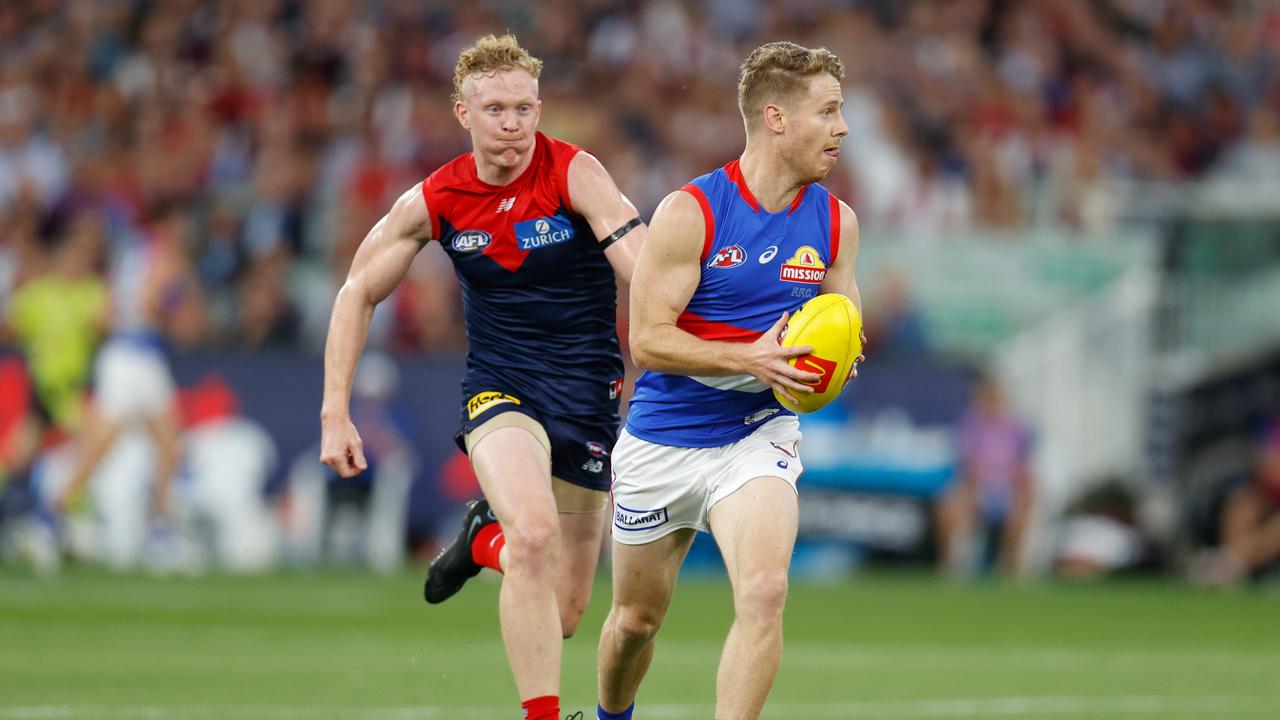 Lachie Hunter of the Bulldogs is chased by Clayton Oliver of the Demons. Photo by Michael Willson/AFL Photos via Getty Images.