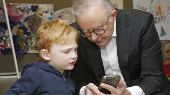 SYDNEY, AUSTRALIA - NewsWire Photos AUGUST 8, 2024:  L to R: Ned Walker -5 with Prime Minister Anthony Albanese. Prime Minister as he shows Ned a picture of his son and his dog.  Anthony Albanese, with Minister for Education, Jason Clare, and the Minister for Early Childhood Education and Youth, Dr Anne Aly at the is in Sydney today with the Minister for Education, Jason Clare, and the Minister for Early Childhood Education and Youth, Dr Anne Aly at the Styles Street Children's Community Long Day Care Centre in Leichhardt. The Government announced a 15%  pay rise for Early Childhood Educators.  Picture: NewsWire / John Appleyard