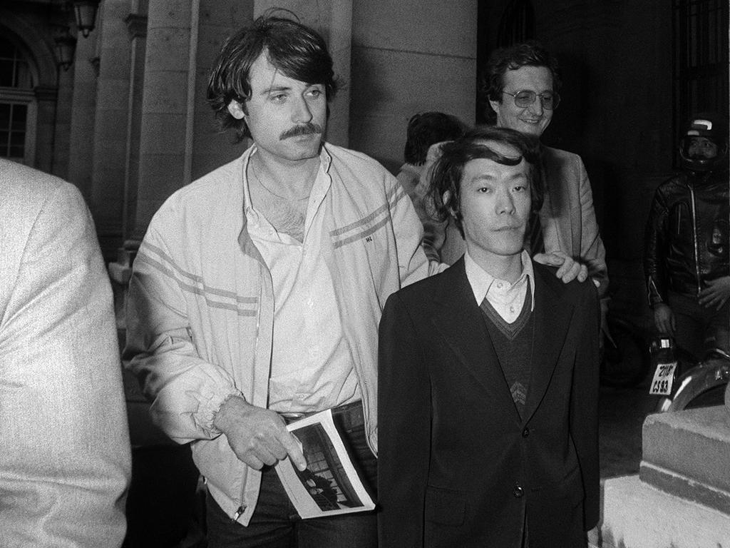 This file photo taken on June 17, 1981 shows Japanese student Issei Sagawa (R) being escorted by French plainclothes police as he leaves the Paris Police Prefecture Headquarters after questioning.