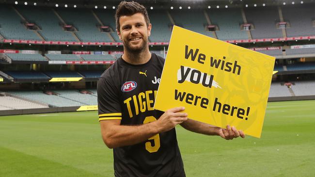 Trent Cotchin of the Tigers holds a sign for the fans at an empty stadium in Round 1. Picture: Michael Klein