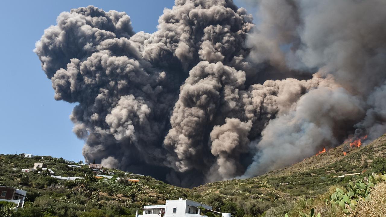 Smoke billows and flames above the hillside near house. Picture: Giovanni Isolino/AFP.