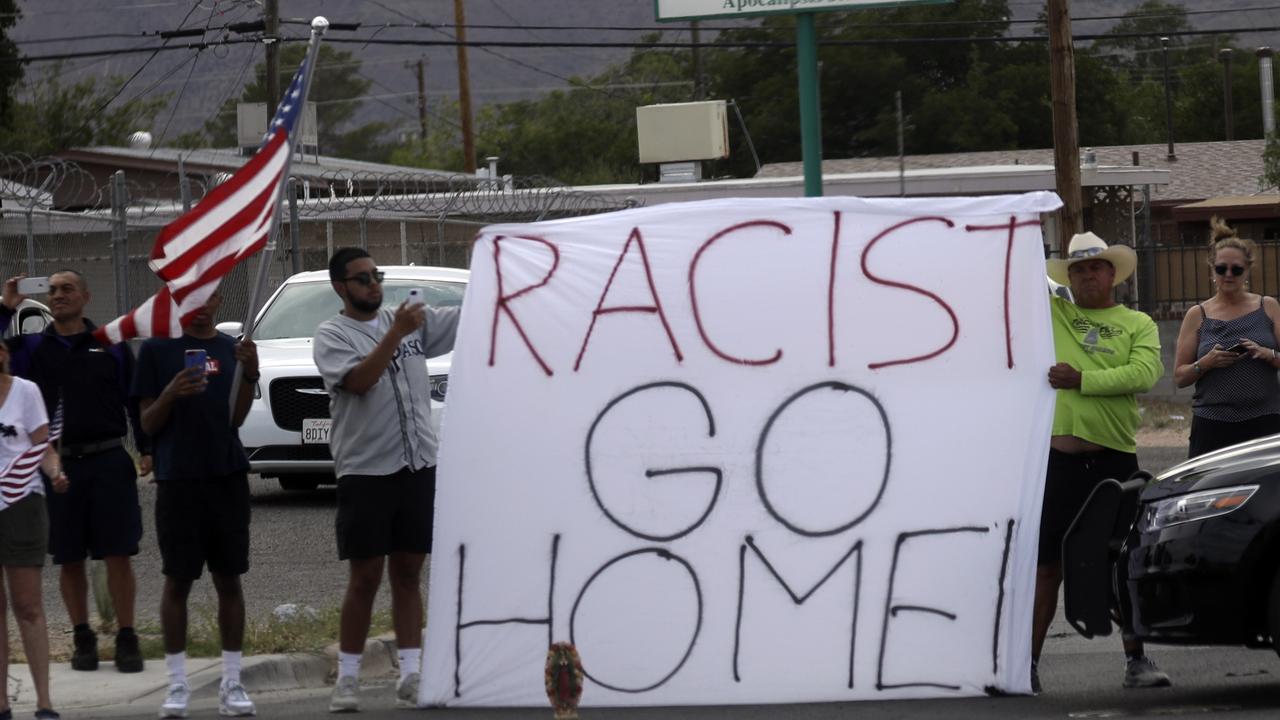 Demonstrators hold a sign as the motorcade carrying President Donald Trump departs a joint operations center after meeting with first responders after the El Paso mass shooting. Picture: AP