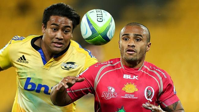 Reds halfback Will Genia and Hurricanes winger Julian Savea fight for the ball.