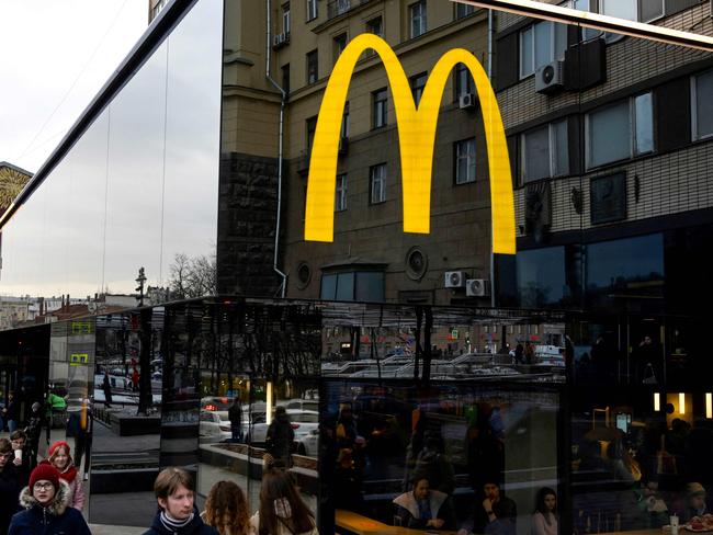 People walk past the McDonald's flagship restaurant at Pushkinskaya Square – the first one of the chain opened in the USSR on January 31, 1990.