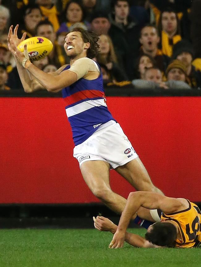 Marcus Bontempelli pushes Luke Hodge over and marks, then goals to get the Dogs back in the game in the second term. Picture: George Salpigtidis