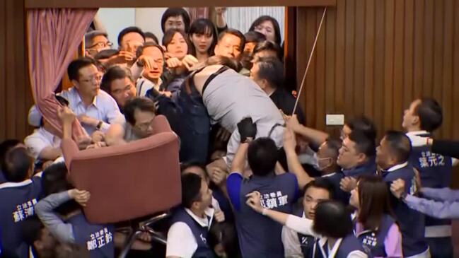 Taiwanese lawmaker climbs over crowd amid chaos