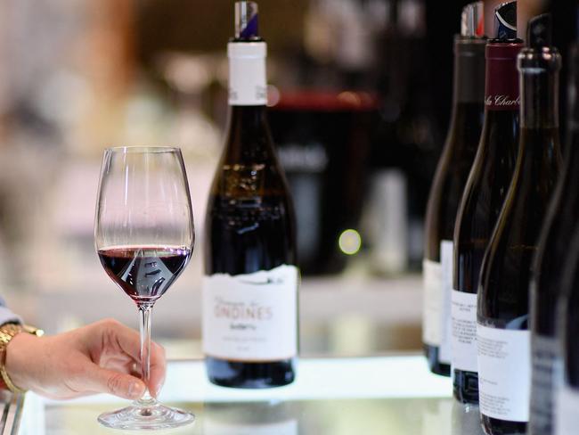 (FILES) An exhibitor swirls a glass of red wine during the Vinexpo at Javits Center on March 2, 2020 in New York City. As President-elect Donald Trump vows sweeping tariffs on even America's close partners once in office, US wine merchants and restaurateurs are watching with trepidation -- and pushing for exclusions they say will protect small businesses. (Photo by Angela Weiss / AFP)