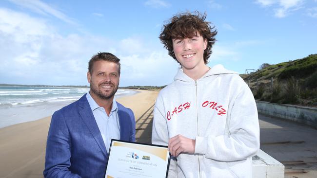 Ocean Grove SLSC member Roo Robinson has been recognised for his off-duty rescue in January, saving a man caught in a rip. LSV general manager lifesaving services Liam Krige handed over an award certificate and letter of commendation at the clubhouse on Wednesday. Picture: Alan Barber