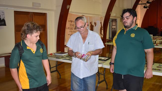 Mr Wrench explaining the history behind the different medals to school students Jacob Masters and Bevan Wrench. (Picture: Kristen Camp)