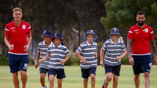 Adelaide United players Kristian Opseth and Paul Izzo with students Luca Fouyaxis 10, Charlotte Zhang 9, Nicholas Belegris 9 and Claudia Lee 9 at Immanuel College.