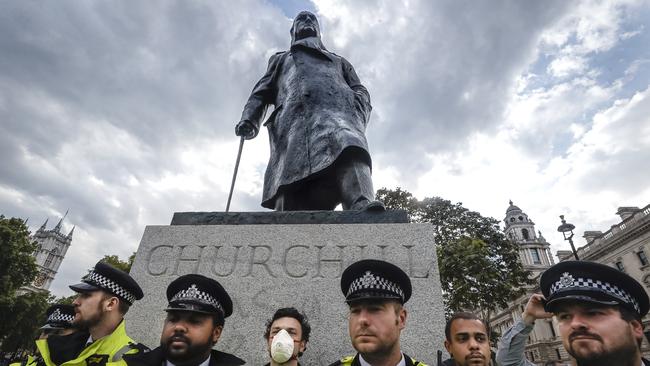 Police officers stand guard in front of the Winston Churchill statue during a rally in Parliament Square in London.