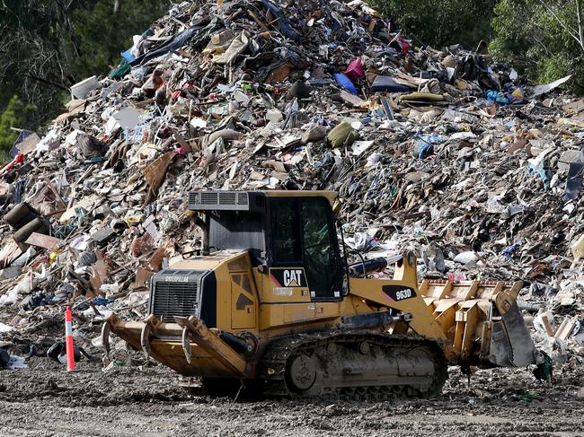 PORT MACQUARIE , AUSTRALIA - NewsWire Photos APRIL, 7, 2021: Mountains of flood rubbish at the Pembroke Temporary Disaster Recovery Transfer Station at Port Macquarie. Workers from SUEZ Recycling and Recovery Solutions sift through the tons of flood affected household belongings from the hundreds of flood damaged properties in Port Macquarie.  picture: NCA NewsWire /  Nathan Edwards