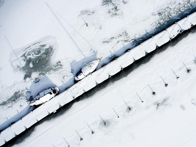 Picture taken with a drone shows snow-covered ships mooring in Kirchdorf on the Baltic Sea island of Poel, northeastern Germany, where bays risk to freeze due to permafrost and night temperatures below minus ten degrees Celsius, on February 27, 2018. A blast of Siberian weather dubbed “The Beast from the East” sent temperatures plunging across much of Europe. Picture: AFP