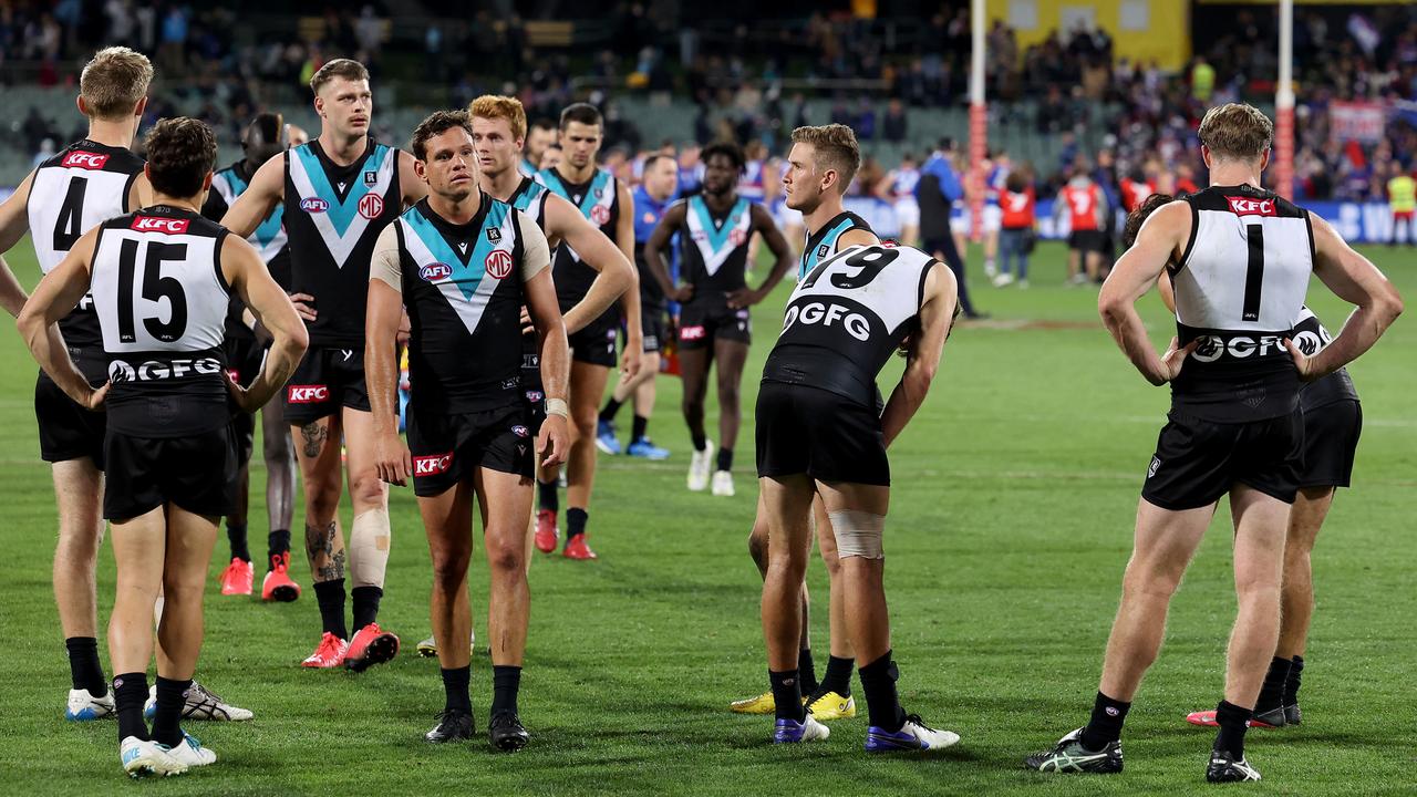 Dejected teammates come to terms with their latest defeat at Adelaide Oval.