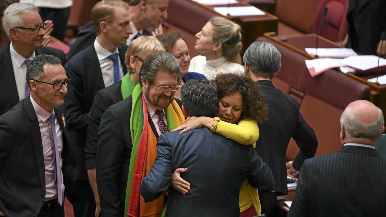 Coalition Senator Dean Smith receives a hug from Labor Senator Malarndirri McCarthy after the same-sex marriage bill passed the Senate in the Senate chamber at Parliament House in Canberra, Wednesday, November 29, 2017. Picture: LUKAS COCH-AAP