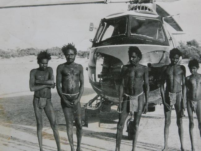 Micky Candle, Government, Brandy Tjungurrayi, Wimmitji and Johnny Napapantji pose in front of the Bristol Sycamore helicopter. Picture: Jim Fersuson, used with permission of Helicopter Tjungurrayi