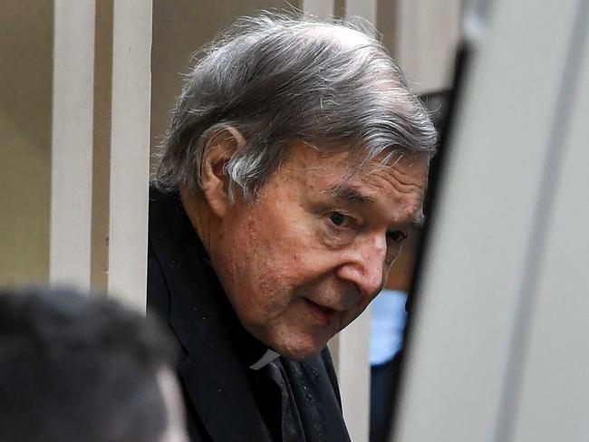 Australian Cardinal George Pell (C) is escorted in handcuffs from the Supreme Court of Victoria in Melbourne on August 21, 2019. - Disgraced Catholic Cardinal George Pell was sent back to jail after an Australian court rejected his landmark appeal against convictions for child sex abuse. (Photo by William WEST / AFP)