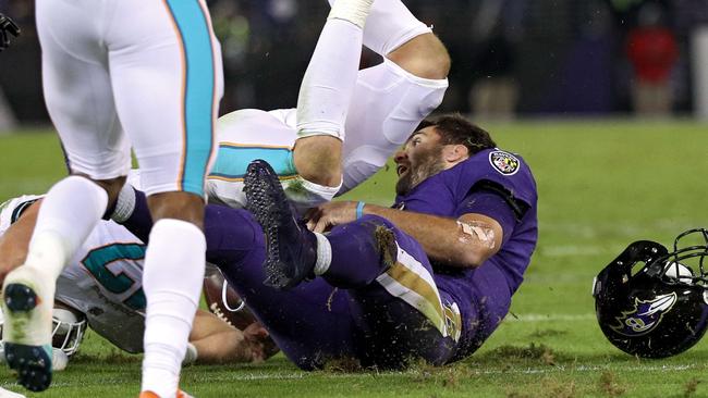 Quarterback Joe Flacco of the Baltimore Ravens is tackled by middle linebacker Kiko Alonso.